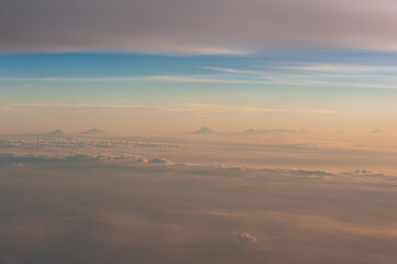 Volcanoes rising from a sea of clouds at sunset, Java, Indonesia