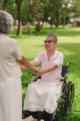 Asian elderly couple holding hands park man wheelchair support emotional connection love senior...