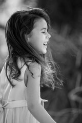 Lifestyle portrait of laughing child girl in black and white, childhood memories and summer holidays concept