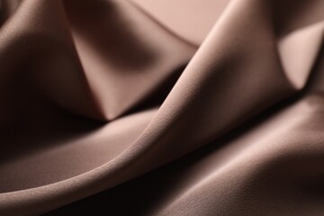 Crumpled light brown silk fabric as background, closeup