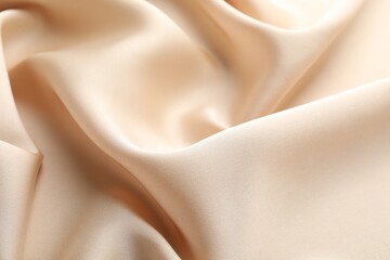 Fototapeta premium Crumpled beige silk fabric as background, above view