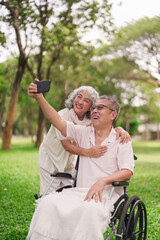 Asian Older Couple Taking Selfie Park Man Wheelchair Woman Standing Behind Happy Retirement Life