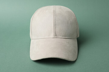 Beige baseball hat on green background, closeup. Mockup for design