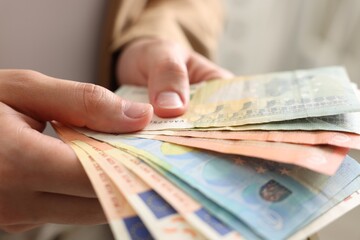 Woman counting her money indoors, closeup view