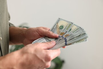 Man counting his money indoors, closeup view
