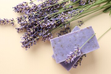 Aromatic soap bars and lavender flowers on beige background, flat lay