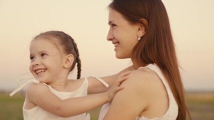 happy family. mother plays with child daughter nature. kid mom kiss and hug outdoor. happy family...