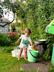 little girl pouring water into a bucket