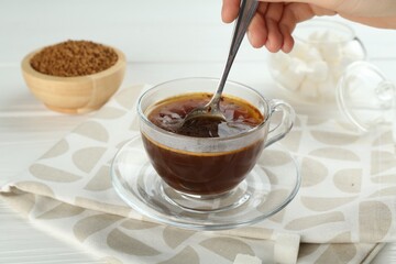 Woman making instant coffee at light table, closeup