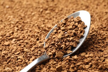 Spoon with aromatic instant coffee as background, closeup