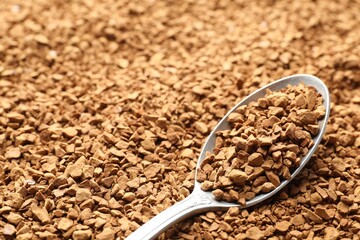 Spoon with aromatic instant coffee as background, closeup