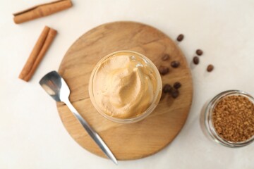 Delicious dalgona coffee in glass, beans, granules and cinnamon on white table, flat lay