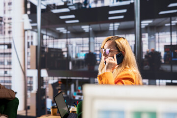 Determined businesswoman speaking on a phone call to ensure project development success,...