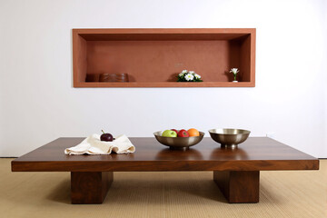 Minimalist Japanese interior featuring a low wooden table with fruit bowls on a tatami mat floor, embodying principles of zen, simplicity, and wabi-sabi design in a tranquil room