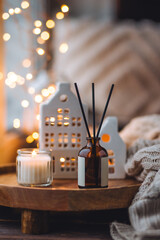 Christmas home aromatherapy. Aroma diffuser with pine extract, organic essential oil, vanilla, gingerbread cookies, candles on wooden table. Cozy atmosphere, holiday spirit. Winter inspiration