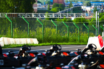 Go-kart race track with protective barriers, green safety fence, and starting LED light system....