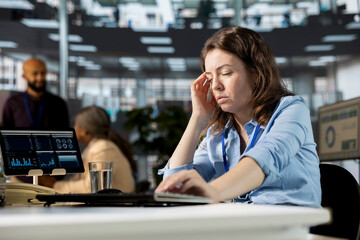 Unwell tired employee deals with a severe headache at the workstation, feeling sick and overworked...