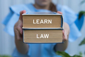 Young girl holding two books with inscription on side: LEARN LAW. Learn Law and AI Ethics...