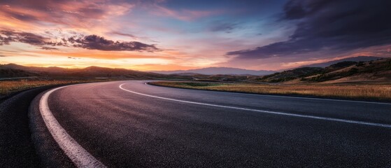 The winding road through a picturesque countryside at sunset.