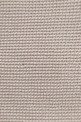 Textured fabric close-up showing a beige woven pattern in natural light