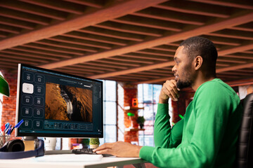 Smiling man at home getting tasks done with AI program turning text prompt into videos. Happy...