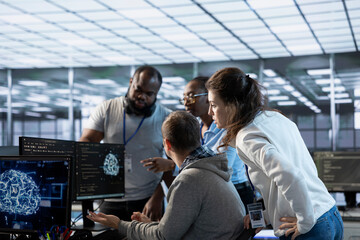 Engineer doing brainstorming with colleagues to fix error in code affecting server room AI...