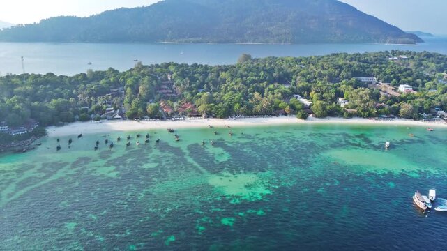 aerial view of beautiful crystal clear water and white sand beach with long tail boats