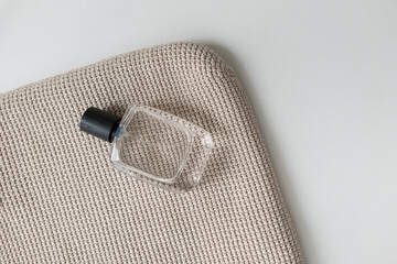 Elegant perfume bottle placed on a textured beige surface during daylight hours