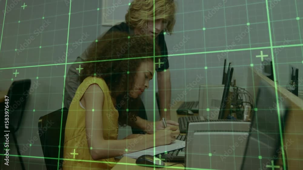 Poster instructor approaching student in computer lab pointing out screen details while jotting notes