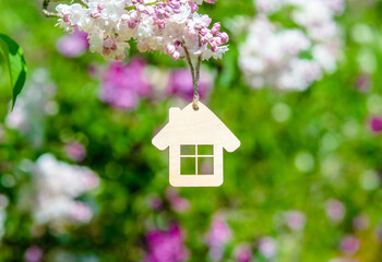 The symbol of the house among the branches of the pink lilac