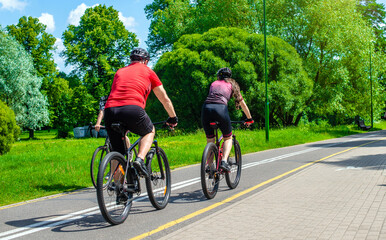 Obraz premium Cyclists ride on the bike path in the city Park 