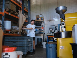 Worker Handling Coffee Bean Sack