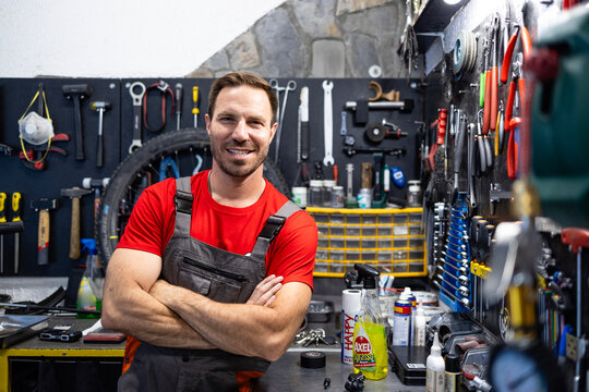 Portrait of caucasian bicycle mechanic holding arms crossed.