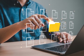Person interacting with a digital interface selecting a yellow folder icon surrounded by document icons and glowing particles