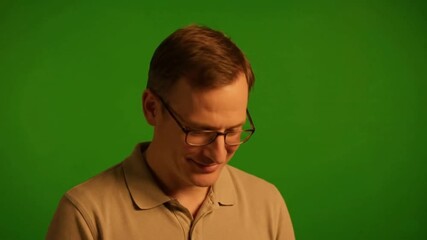 Man with Glasses Nodding in Agreement on a Green Screen, Showing Understanding, Approval, and Consent