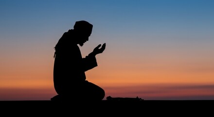 Silhouetted man kneeling in prayer at sunset, hands raised in supplication, peaceful twilight sky.