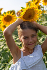 A joyful young child embracing a vibrant sunflower in a sunlit summer field, radiating happiness...