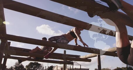 Two fitness partners bracing on wooden beams swinging legs into crawl for obstacle training