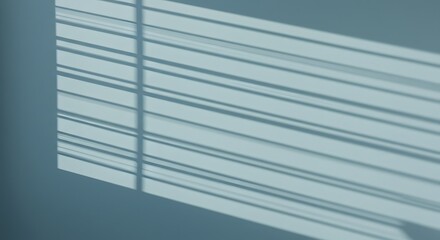 Shadows from blinds cast diagonally across a light blue wall creating a minimalist aesthetic view