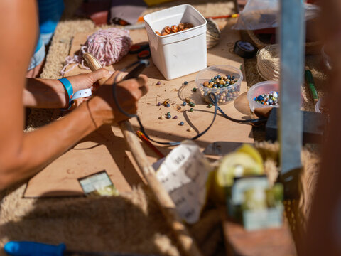 Festival camping table with colorful beads crafts and creative activities in bright sunlight
