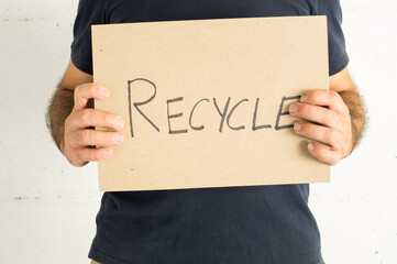 man wearing a navy blue t-shirt with a sign and a message to encourage recycling