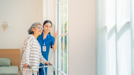 Happy female caregiver take care and talking with senior woman in living room. Retirement...