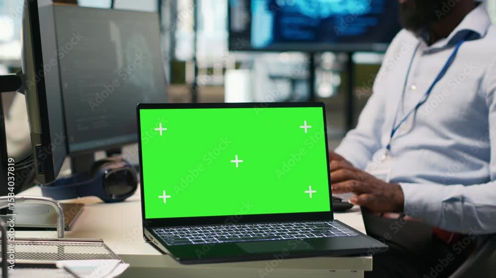 Poster technician next to office coworkers developing software applications using green screen laptop, inte