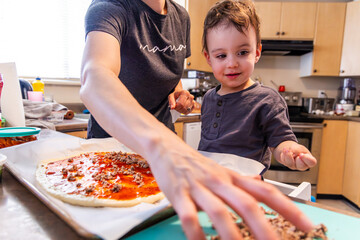 Mother and Toddler Boy Making Homemade Pizza in the Bright Kitchen