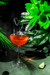 Refreshing orange cocktail featuring mezcal, orange bitters, yellow liqueur, and lime juice