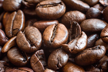 Macro photograph of roasted coffee beans showcasing detailed textures. Perfect for use in advertising, packaging design, blogs, or promotional materials related to coffee themes. Coffee background.