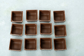 Square-shaped milk chocolate shells ready to be filled_top view.