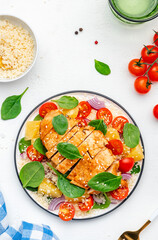 Salad with chicken fillet, couscous, cherry tomatoes, red onion, fresh spinach and orange slices, top view