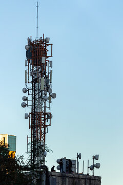 Sao Paulo, SP, Brazil - June 24 th, 2025: Warmly dressed technicians performing maintenance on a telecommunications cabinet at the top of a telco building.