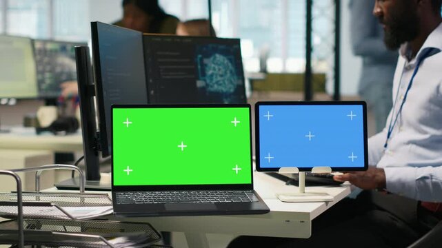 Software developer using AI on isolated screen laptop and tablet to optimize performance and forecast issues. IT expert in office training machine learning models using chroma key notebook, camera A